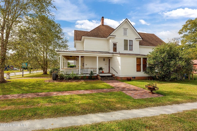 farmhouse featuring a front lawn and a porch