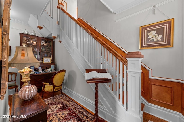 stairway featuring hardwood / wood-style flooring and ornamental molding