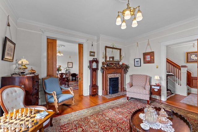 living room featuring hardwood / wood-style floors, a chandelier, and ornamental molding