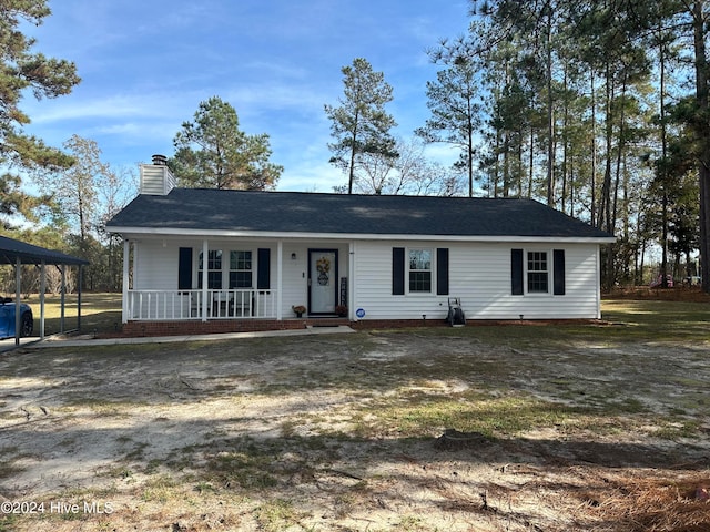 ranch-style home featuring covered porch and a carport