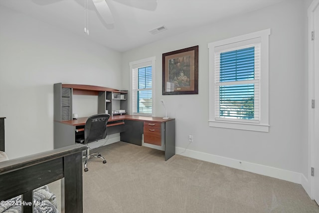 home office with plenty of natural light, ceiling fan, and light colored carpet