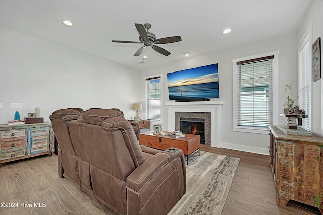 living room featuring ceiling fan, a healthy amount of sunlight, and light wood-type flooring