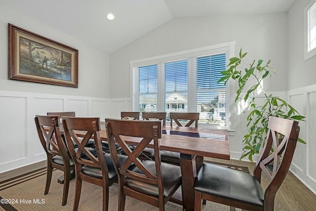 dining space with plenty of natural light, wood-type flooring, and vaulted ceiling