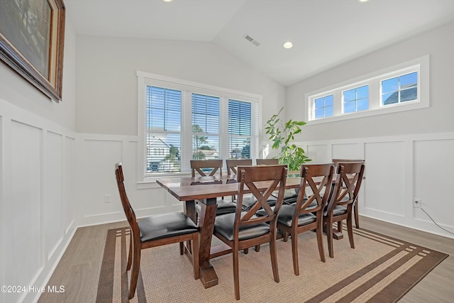 dining area with lofted ceiling, wood-type flooring, and a wealth of natural light