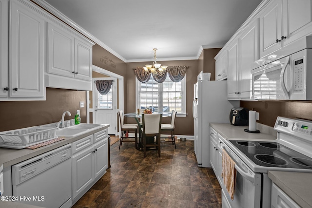 kitchen featuring white cabinetry, sink, pendant lighting, a chandelier, and white appliances