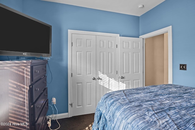 bedroom featuring dark carpet and a closet