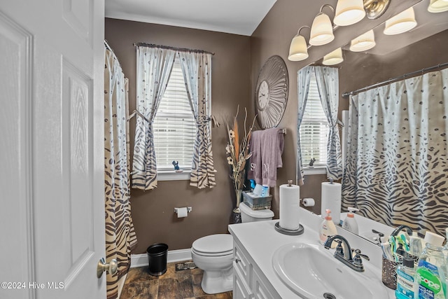 bathroom featuring a wealth of natural light, vanity, and toilet