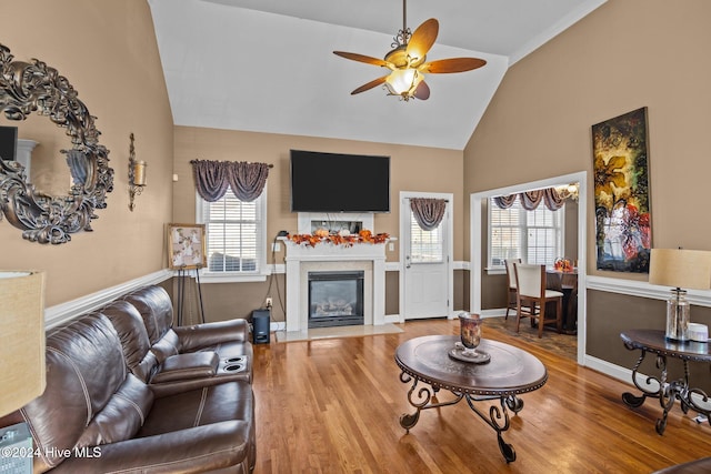 living room featuring hardwood / wood-style flooring, ceiling fan, and high vaulted ceiling