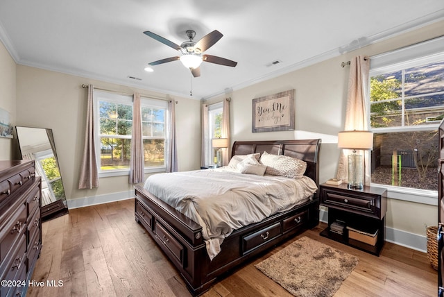 bedroom featuring light hardwood / wood-style flooring, ceiling fan, and ornamental molding