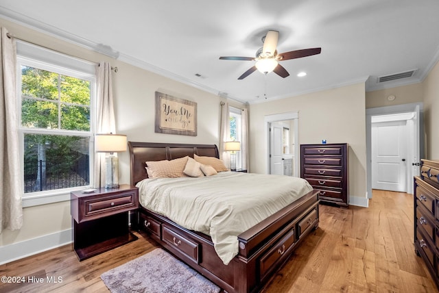 bedroom featuring ceiling fan, ornamental molding, and light hardwood / wood-style flooring