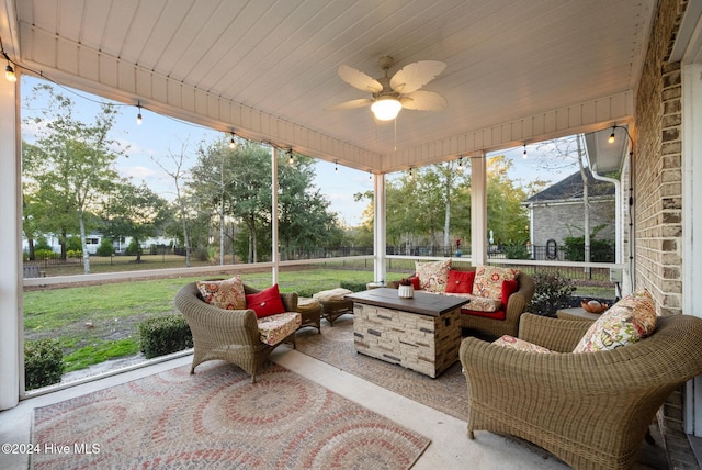 sunroom / solarium with ceiling fan and an outdoor living space with a fire pit