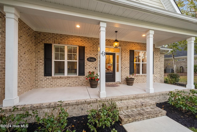 property entrance with brick siding and a porch