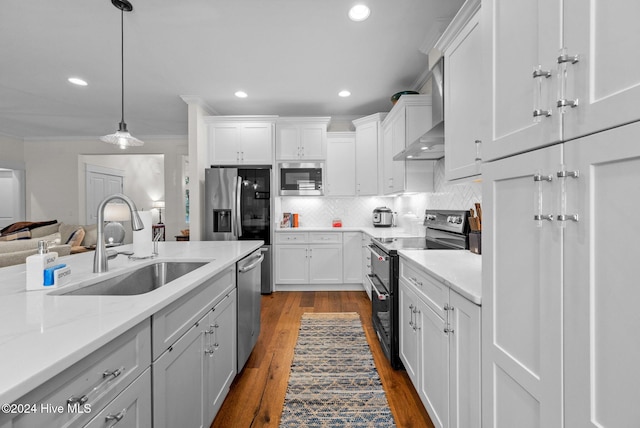 kitchen with appliances with stainless steel finishes, sink, white cabinetry, and wood-type flooring