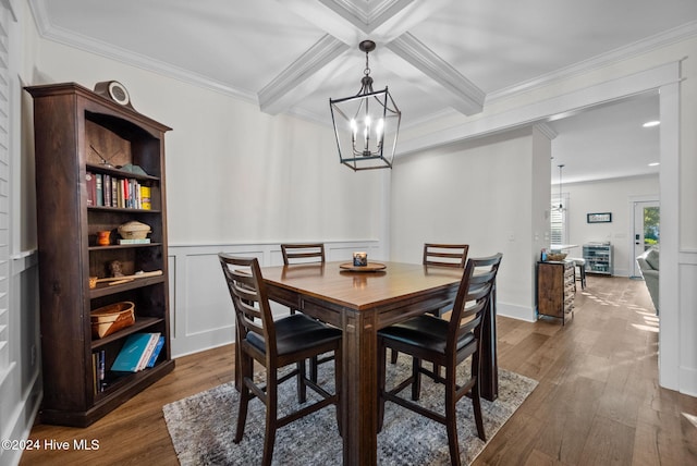 dining room featuring beam ceiling, ornamental molding, an inviting chandelier, and dark wood-type flooring