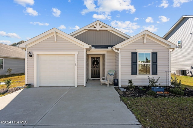 view of front of property featuring a garage and central air condition unit