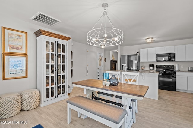 dining area with a chandelier and light hardwood / wood-style floors