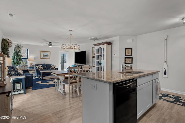 kitchen featuring white cabinetry, sink, black dishwasher, an island with sink, and light wood-type flooring