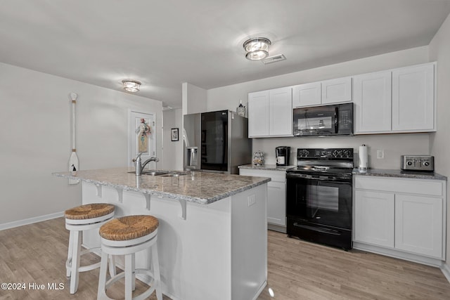 kitchen with black appliances, light hardwood / wood-style floors, white cabinets, and sink