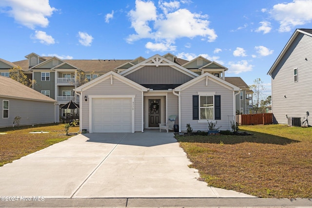 view of front of home featuring central AC unit, a garage, and a front yard