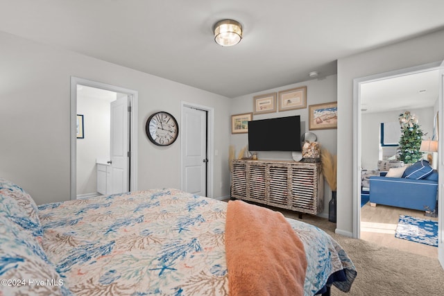 bedroom with hardwood / wood-style flooring and ensuite bath