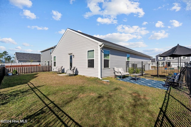 rear view of property with a lawn and a patio area