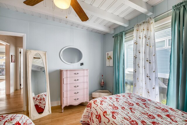 bedroom featuring beamed ceiling, hardwood / wood-style flooring, and ceiling fan