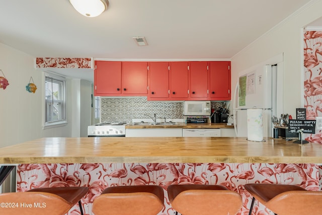 kitchen featuring sink, wood counters, tasteful backsplash, white appliances, and ornamental molding