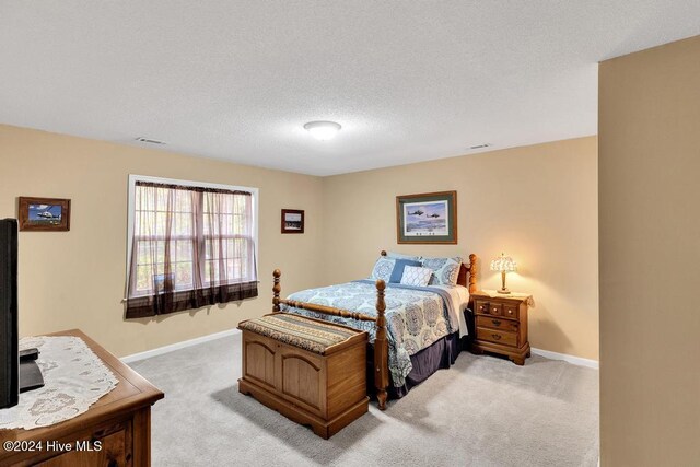 carpeted bedroom with a textured ceiling