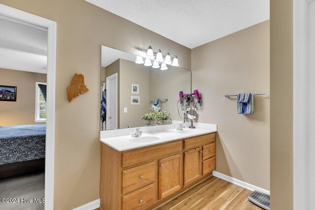 bathroom featuring a textured ceiling, vanity, and hardwood / wood-style floors