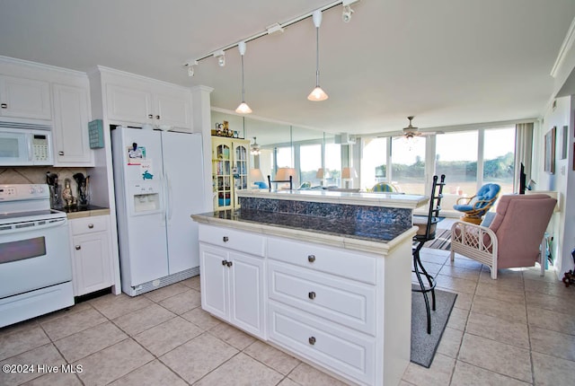 kitchen with a kitchen breakfast bar, white cabinetry, light tile patterned flooring, and white appliances