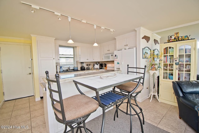 kitchen with white cabinetry, sink, decorative light fixtures, white appliances, and light tile patterned floors