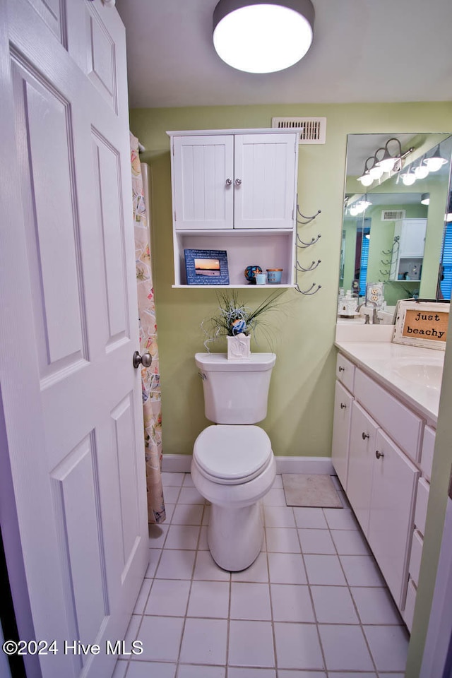 bathroom with tile patterned flooring, vanity, and toilet