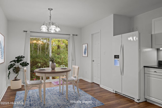 dining space featuring a notable chandelier, baseboards, and dark wood-style flooring