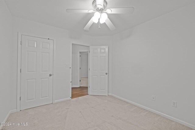 unfurnished room featuring ceiling fan and light carpet