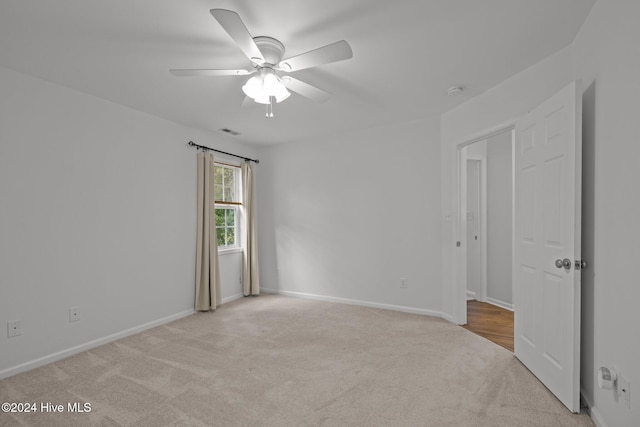 unfurnished room featuring light carpet and ceiling fan