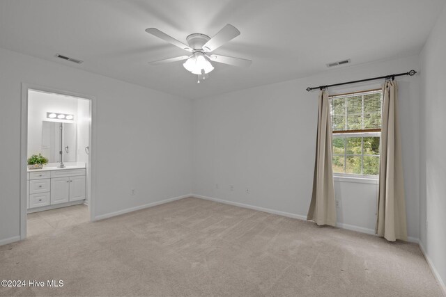 spare room with a ceiling fan, carpet, visible vents, and baseboards