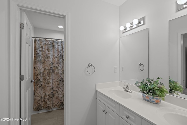 full bathroom with a sink and double vanity