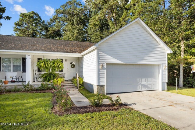 ranch-style house with a garage, covered porch, a front lawn, and concrete driveway