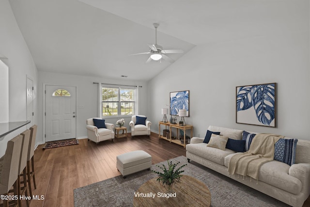 living room with lofted ceiling, ceiling fan, baseboards, and wood finished floors