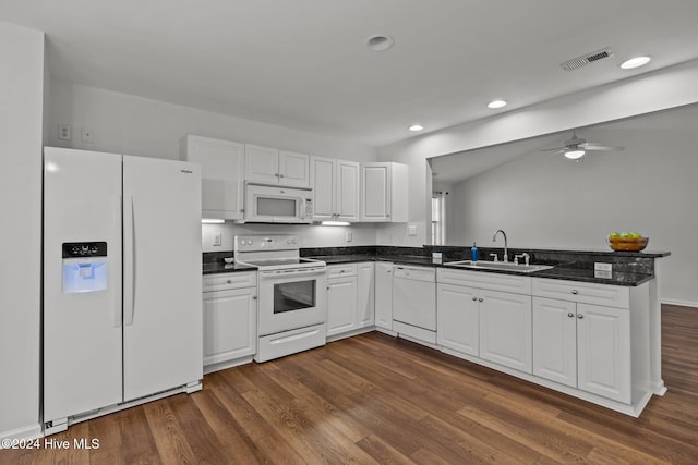 kitchen featuring white appliances, white cabinets, dark wood-style floors, a peninsula, and a sink