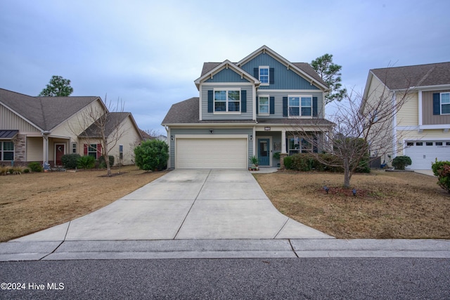 craftsman-style house featuring covered porch, a garage, and a front lawn