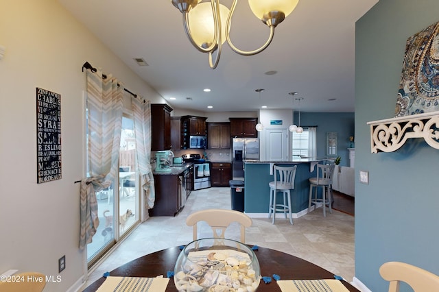 tiled dining room with a notable chandelier