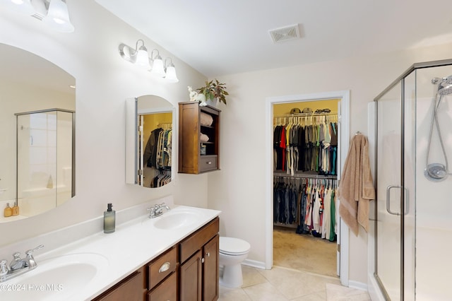 bathroom with toilet, tile patterned flooring, vanity, and walk in shower