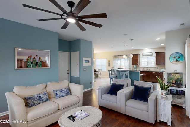 living room featuring dark hardwood / wood-style floors, ceiling fan, and sink