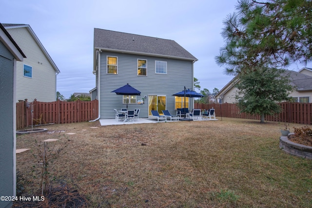 back of house with a patio and a lawn