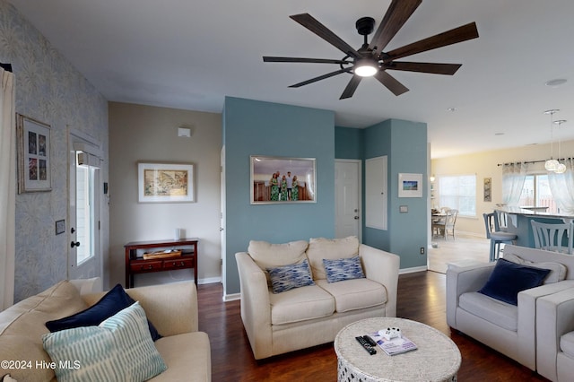 living room with ceiling fan and dark wood-type flooring