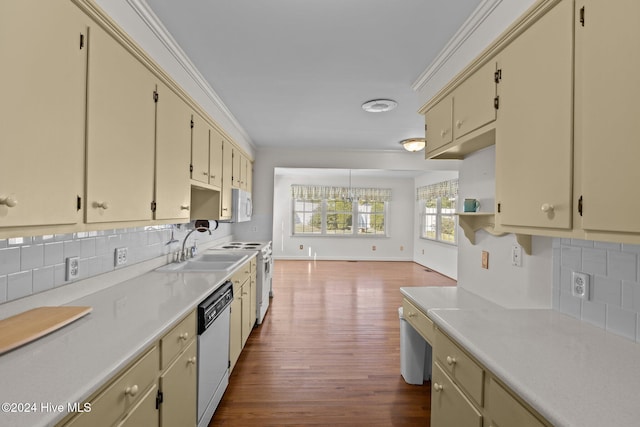 kitchen featuring white appliances, cream cabinets, dark hardwood / wood-style floors, ornamental molding, and tasteful backsplash