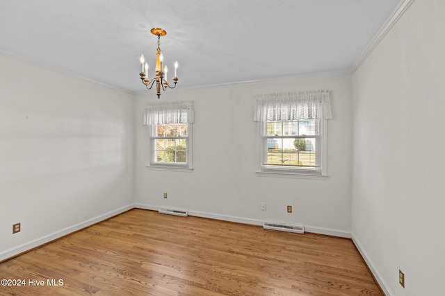 empty room featuring light wood-type flooring, ornamental molding, and an inviting chandelier