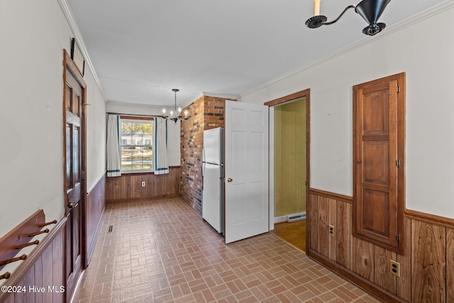 kitchen with white fridge, hanging light fixtures, and wooden walls