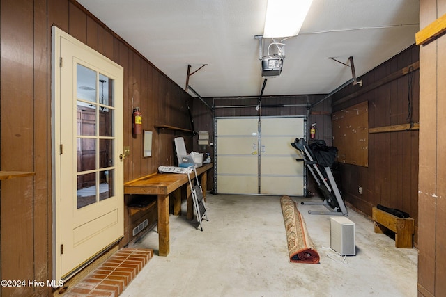 garage with wood walls and a garage door opener